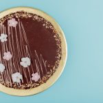 top view of chocolate cake with nuts on blue background with copy space top view of chocolate cake with nuts on blue background with copy space